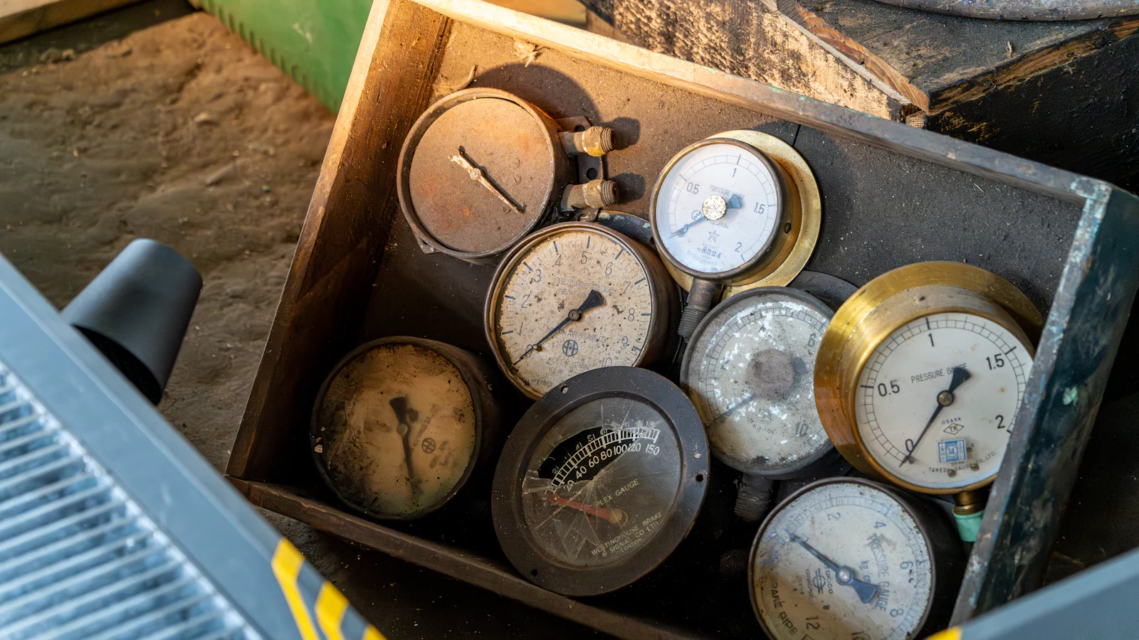 A wooden crate of retired pressure gauges, each needle at a different reading, as a sprint is better read from several instruments than from one line