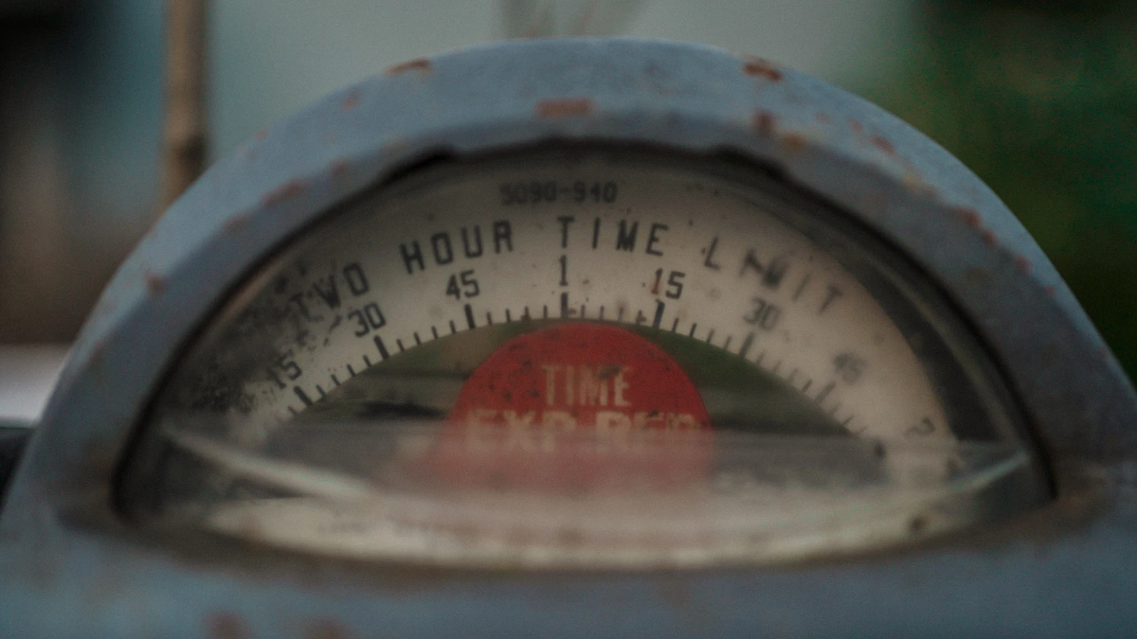 A weathered parking meter with a two-hour time limit, its red flag showing time expired, charging for time spent standing still as an undecided item does