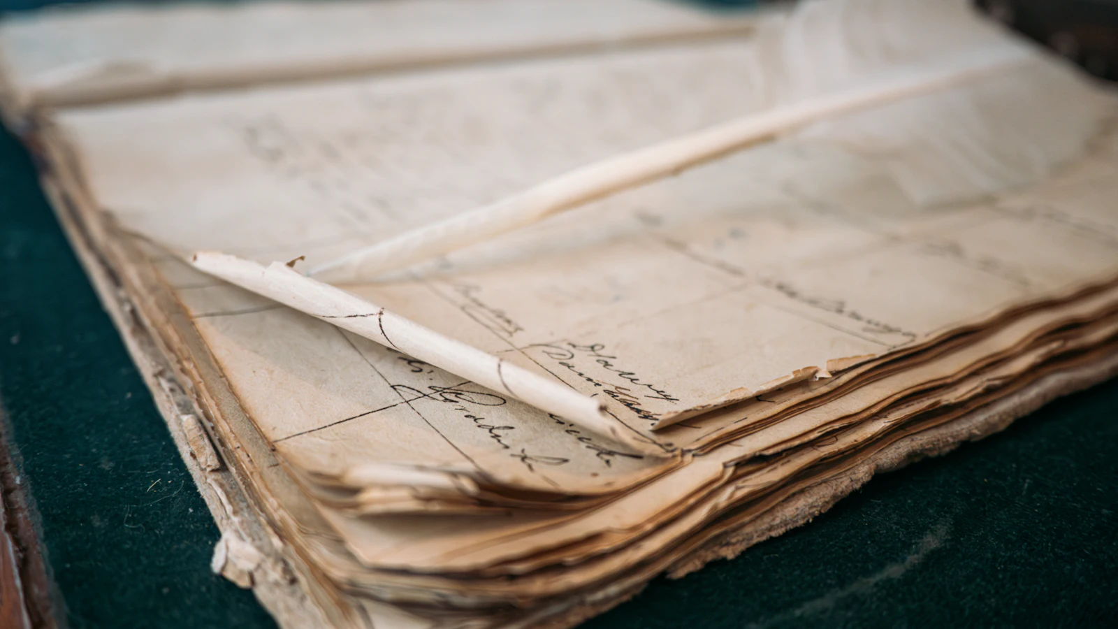 A quill pen laid across the worn, hand-ruled pages of an old ledger: a record kept by hand, where a correction stays visible instead of replacing what was written before