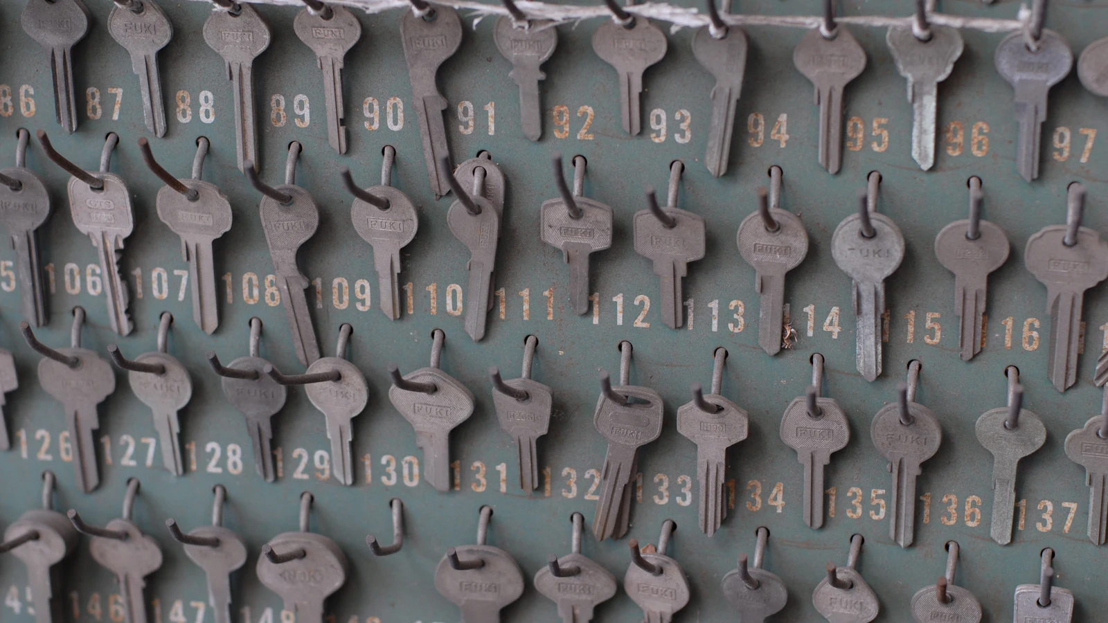 A numbered key board with a key on most hooks and a few hooks bare, each key opening one door and the gaps showing exactly what is currently issued